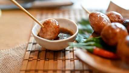 Thai Isaan sausage dipping in special traditional sauce.