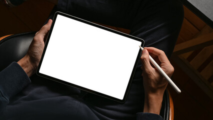 A digital tablet touchpad white screen mockup is on a male hands.