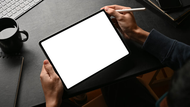 A male graphic designer using his modern digital tablet touchpad at workspace.