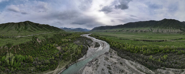 The river flows through green mountain hills