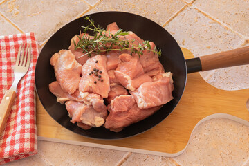 top view of piece of raw veal in frying pan on wooden board