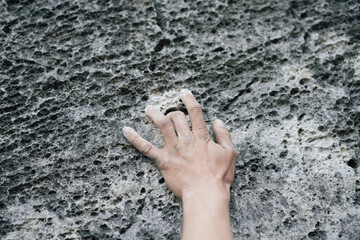 Adult male handholding on to a rock