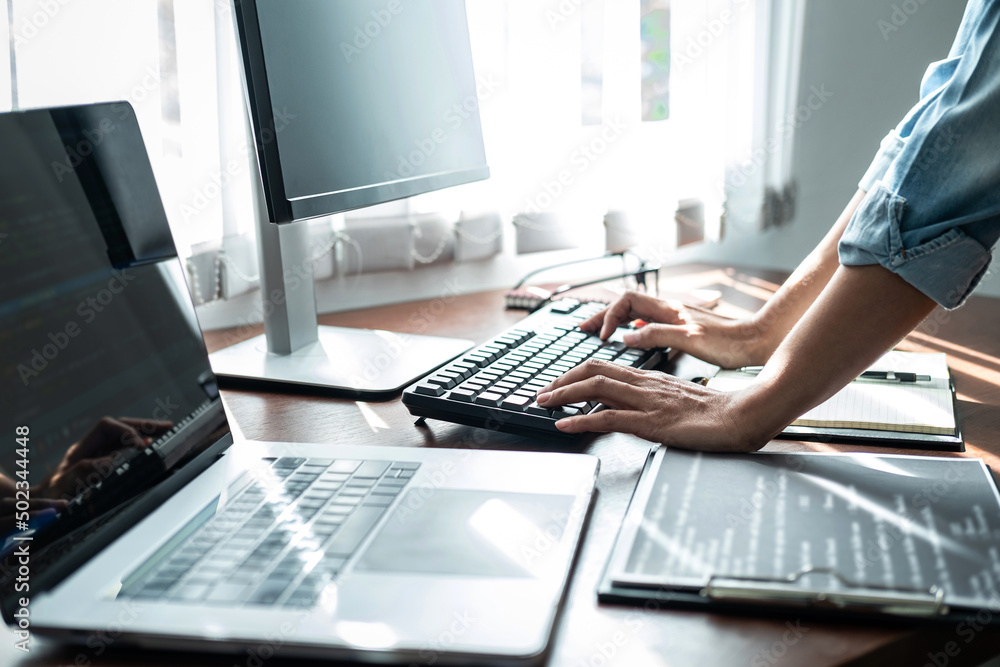 Poster asian woman programmer is writing code data with keyboard on laptop for new website or applications