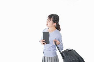 ガイドブックを持ち一人旅をする若い女性