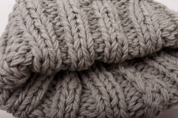 Knit grey fabric texture, background or backdrop. Textile, scarf or sweater textured surface. Warm accessories, clothing, fashion concept.