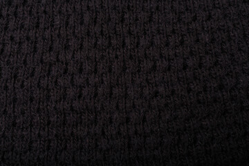 Knit black fabric texture, background or backdrop. Textile, scarf or sweater textured surface. Warm...