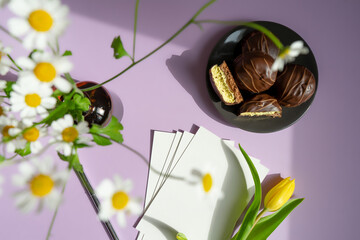 Festive banner of the color of the year 2022 is very peri. Yellow tulip on pastel background with card and pen. Mother's day, birthday, celebration concept, congratulations. Copy space, top view, gree