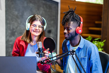 young girl interviewing an african american rap artist, live streaming a web radio broadcast, using...