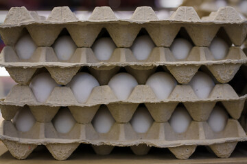 Hen eggs in reusable paper containers in grocery store or supermarket. Easter sale, zero waste, eco packaging.