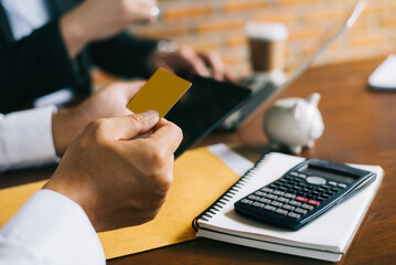 Businessman hold credit cards, conduct financial transactions via tablets and financial analysis...