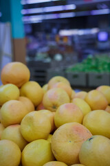 Exotic citrus fruit in supermarket or grocery store, shop. Heap of oranges on counter