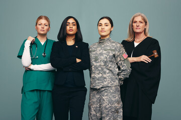 Four women from different occupations standing in a studio