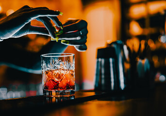 woman bartender hand making negroni cocktail. Negroni classic cocktail with gin short drink, sweet...