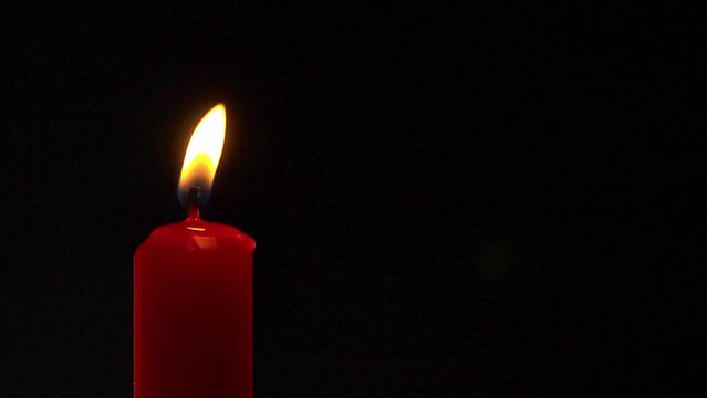 A red candle flame flickers, seamless loop, slow motion