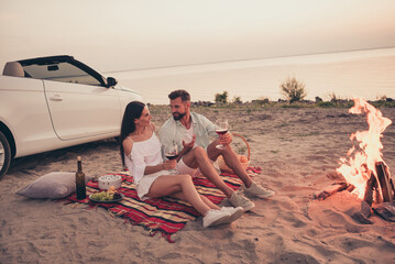 Photo of pretty sweet married couple dressed white clothes driving car enjoying red wine smiling...