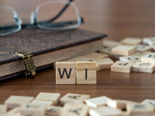 the acronym wi for when issued word or concept represented by wooden letter tiles on a wooden table...