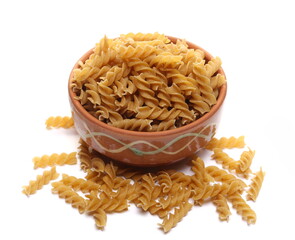 Pile wholemeal, integral pasta spirali in clay pot isolated on white 