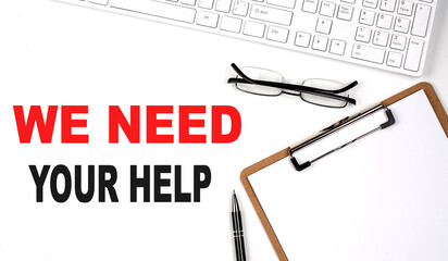 WE NEED YOUR HELP text written on the white background with keyboard, paper sheet and pen