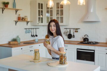 Young attractive woman trying to prepare pasta in kitchen