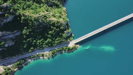Aerial footage a car driving over a bridge on Piva Lake