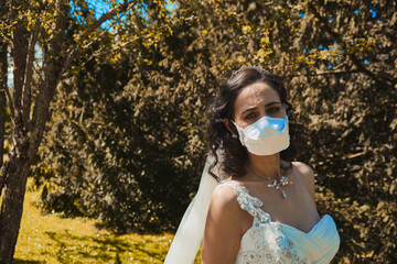 Bride with a mask to protect herself from Covid 19. Wedding in the new normal