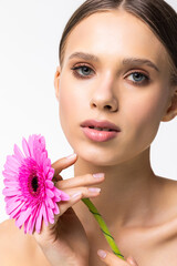 Fototapeta premium Portrait of beautiful smiling young woman with a flower on white background