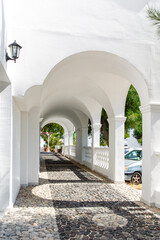 Arched corridor with columns in a traditional Greek white house.