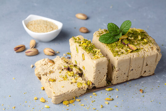 Sesame halva with pistachios on grey background. Top view. Copy space. Traditional middle eastern sweets. Jewish, turkish, arabic national dessert. Turkish delight.