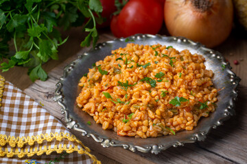Traditional turkish bulgur pilaf with tomato sause in plate (Turkish name; meyhane pilavi)
