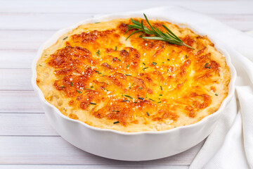 Potato gratin - graten (baked potatoes with cream and cheese) with rosemary and forks (Turkish name; Kremali patates)