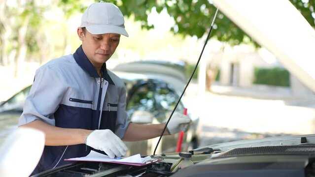 Auto mechanic checking and maintenance to customer the engine a vehicle car hood and masters inspector replaces the damaged parts in car while checking the work of the car. Service, repair concept