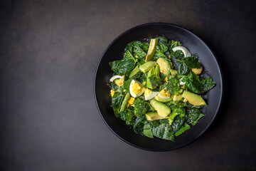 Avocado salad with broccoli, boiled egg in white vintage bowl on light salad