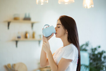 Beautiful young woman drinking a cup of coffee at home.