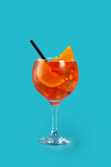 Glass of aperol spritz cocktail on blue background