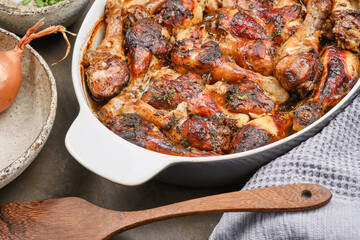 Hot homemade chicken with balsamic vinegar sauce in a baking dish with wooden kitchen spatula . Shallow depth of field