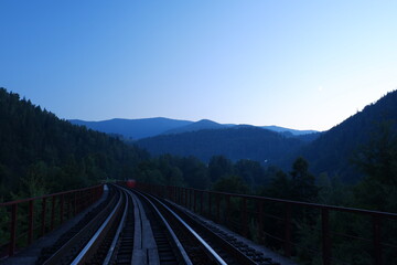 Fototapeta na wymiar Railway among the Ukrainian mountains at sunset