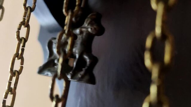 Antique wall clock with a pendulum closeup.