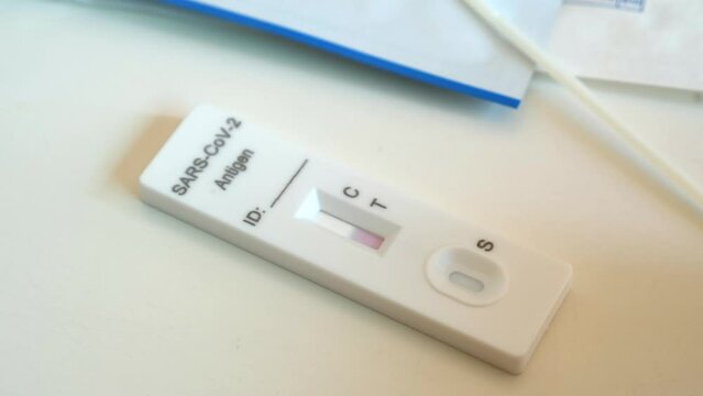 Just used rapid coronavirus atk test without stripes, waiting for result. Fast antigen covid-19 test kit for self diagnosis after using on white table at home pending of results. Pandemic concept.