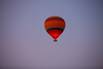 Traditional view of large group of hot air balloons flying at down in cappadocia to admire rock...