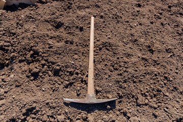 Hand pickax hoe is lying on the soil