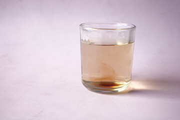 dirty glass of water on purple background 
