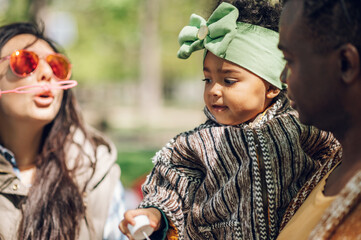Fototapeta premium Diverse family blowing soap bubbles in park