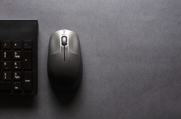 Computer keyboard and mouse on a black background. Copy space