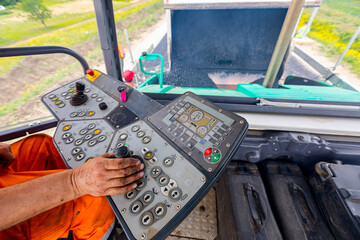 Controller operates the asphalt spreading machine, adjusts manually on the control panel © Roman_23203