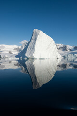 Ice berg reflected in calm water in the Errera Channel in Antarctica