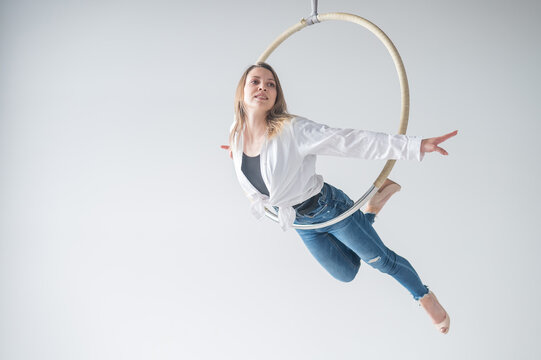 Caucasian woman in casual clothes and high heels shoes on air hoop. - Powered by Adobe