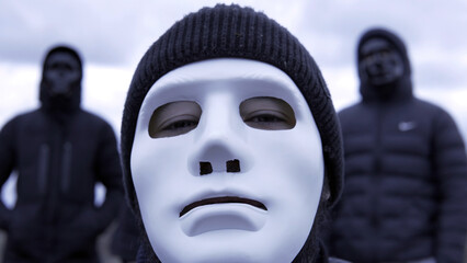 Men in black jackets and masks. Footage. Criminal gang in black plastic masks and leader in white...