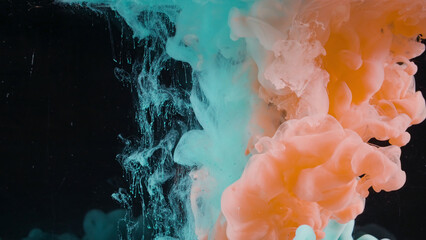 Splash of colored ink in water on black background. Action. Two colors are mixed in water on...