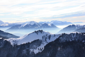 Fototapeta na wymiar vue du roc noir dans les alpes, montagne bleu dans la brume a l'aurore 