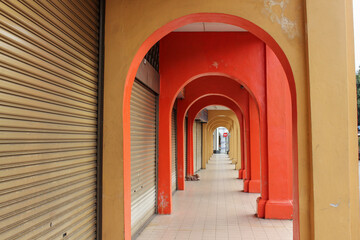 Vintage colourful arches of a sidewalk alley lined with closed shops in the world heritage site of George Town in Penang.